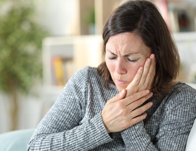 Middle age woman suffering toothache at home