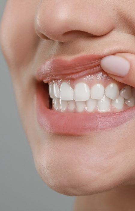 Woman showing healthy gums on grey background, closeup. Space for text