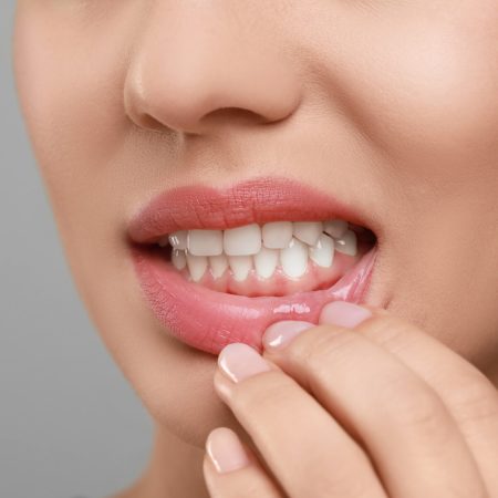 Woman showing healthy gums on grey background, closeup. Space for text